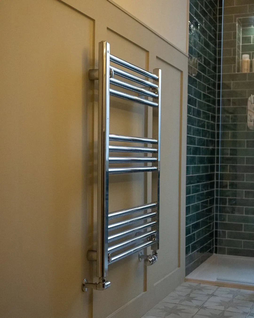 Chrome heated towel rail plumbed onto a panelled wall in a Cardiff bathroom